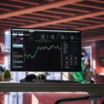 Tela de monitor exibindo gráficos de ações em forte volatilidade no mercado financeiro, representando estratégias de proteção para investidores.