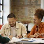 Pessoas analisando documentos e dados em uma mesa, representando análise fundamentalista de ações e FIIs.