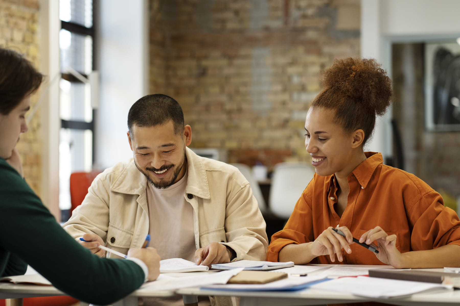 Pessoas analisando documentos e dados em uma mesa, representando análise fundamentalista de ações e FIIs.