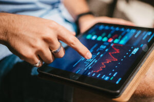 Pessoa analisando gráficos do mercado financeiro e investimentos em ETF em um tablet