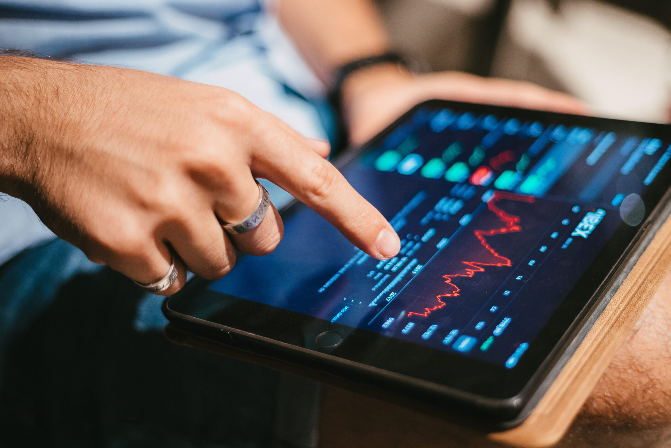 Pessoa analisando gráficos do mercado financeiro e investimentos em ETF em um tablet