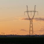 Torre de transmissão de energia elétrica ao pôr do sol em análise sobre as ações da TAEE11