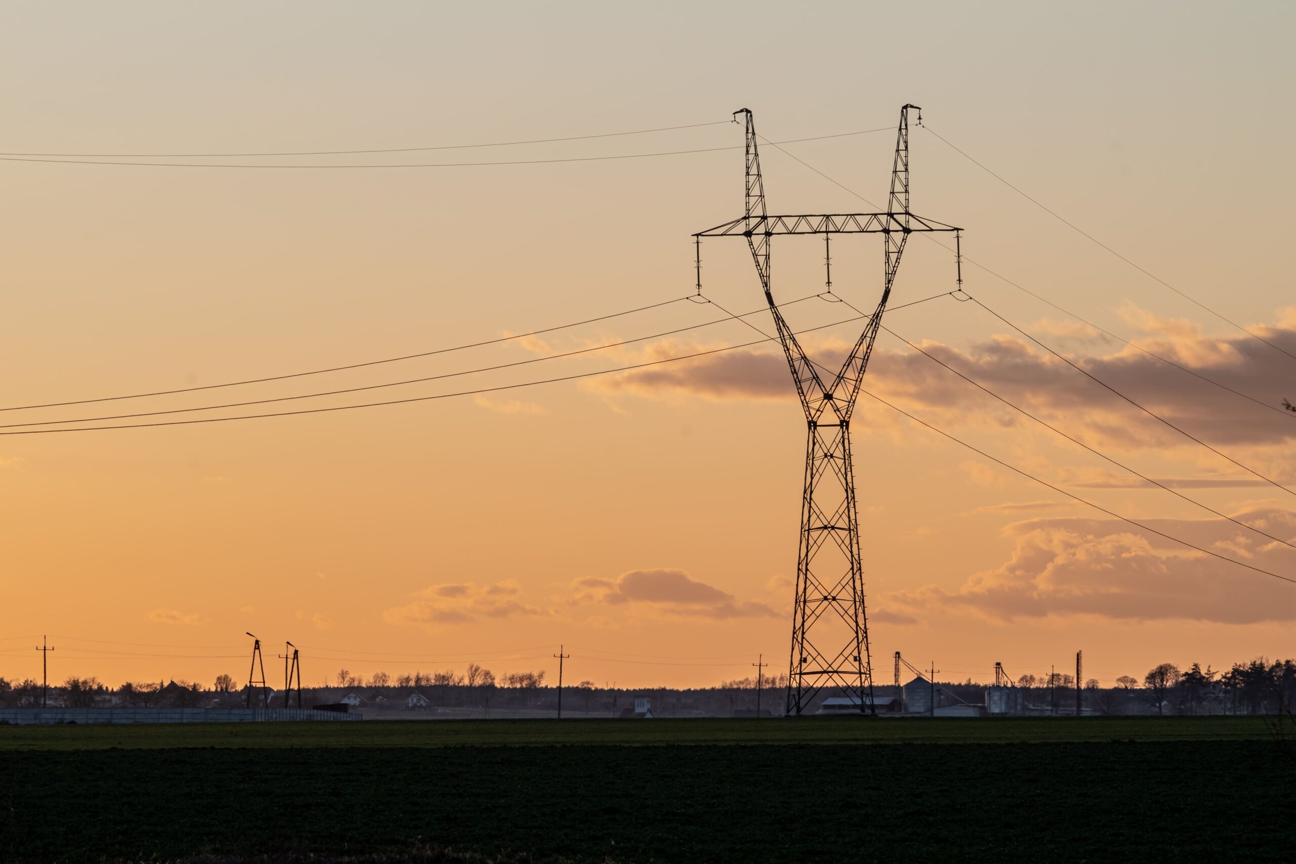 Torre de transmissão de energia elétrica ao pôr do sol em análise sobre as ações da TAEE11
